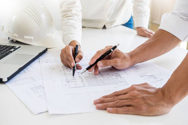 istock Male Architects Drawing Blueprint At Desk In Office 1054035732