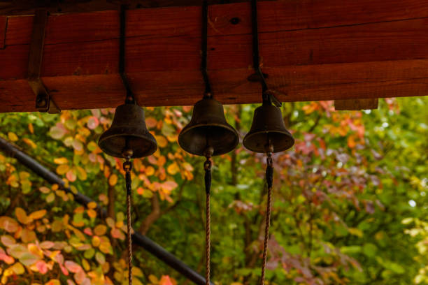 istock Three small bells hangs on brown wooden beams 1054045134