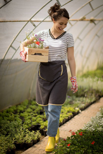 istock Young woman walking through the greenhouse 1054061266