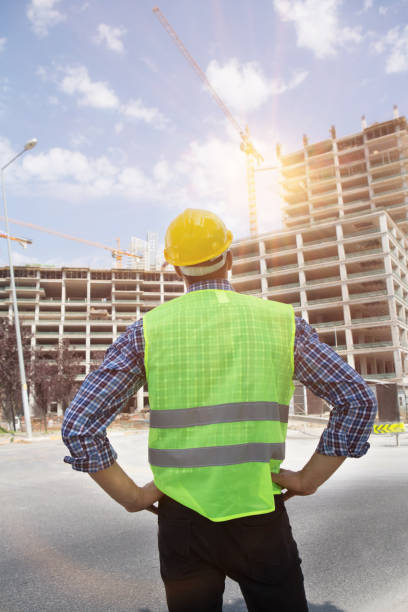 istock Young Engineer portrait with construction site and crane background. 1054064916