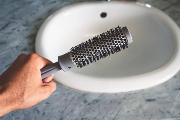 istock Strong man holding a hair brusher next to the sink 1054068170