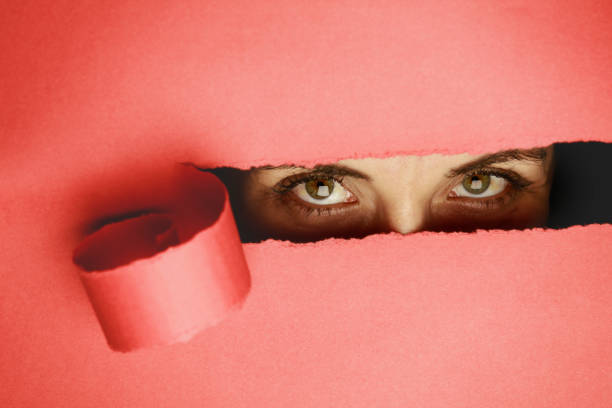 istock Girl watches through a hole in cardboard 1054077542