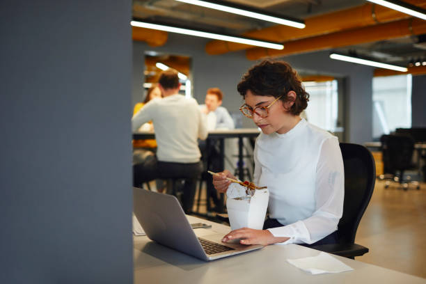 istock Businesswoman Eating in Her Office 1054082362