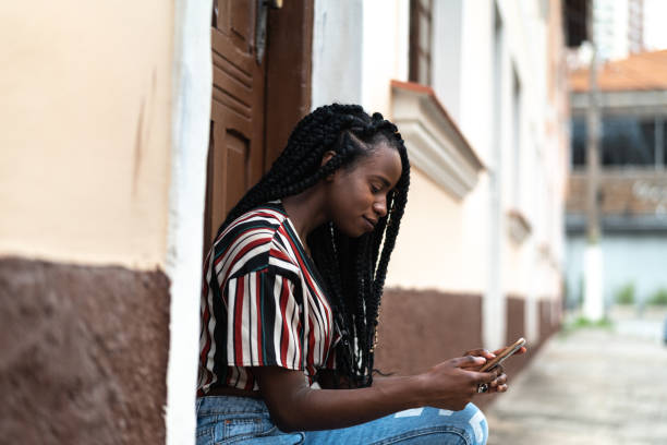 istock African Woman Using Mobile Phone at Street House 1054082712