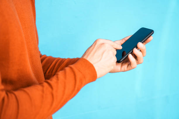 Close up of a man using mobile phone on the colorful wall