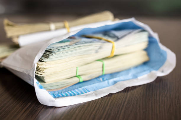 liasse de billets de dollar américain dans une enveloppe blanche sur table en bois. concept de secondaire au noir. salaires de l’enveloppe. corruption et criminalité économique - secondary action photos et images de collection