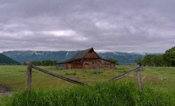 istock Barn Framed by Fence in front of mountains 1054099146