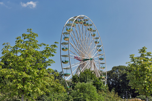 BERLIN, GERMANY - JULY 13, 2018: Ferris wheel against clear blue sky in Tiergarten park. Berlin is the capital and largest city of Germany by both area and population.