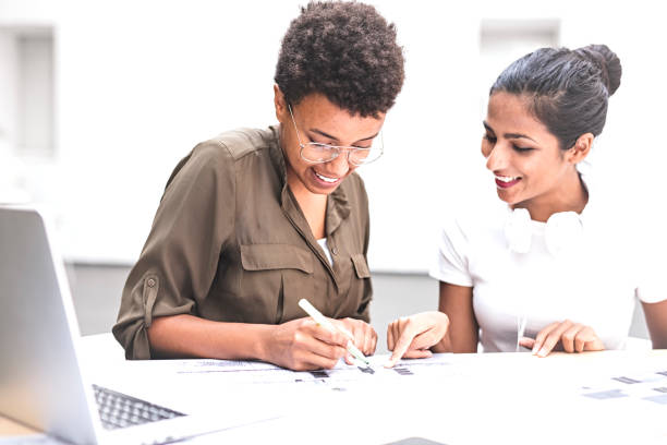 istock Smiling female architects using laptop and discussing  project in meeting 1054109786