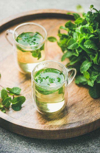istock Hot herbal mint tea drink in glass mugs with leaves 1054146704