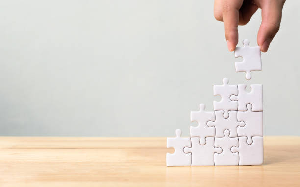 disposizione a mano puzzle impilamento come scala passo su tavolo di legno. concetto aziendale per il processo di successo della crescita - gradino singolo foto e immagini stock