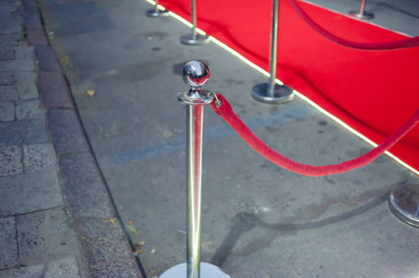 istock Long red carpet between rope barriers on entrance. 1054151164