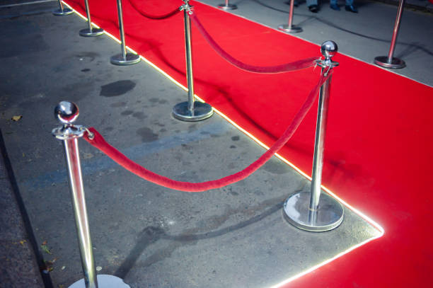 istock Long red carpet between rope barriers on entrance. 1054151234
