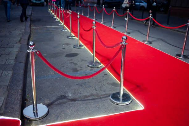 istock Long red carpet between rope barriers on entrance. 1054151280