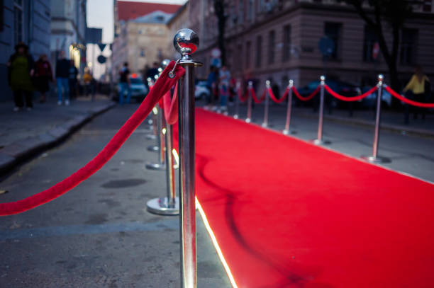 istock Long red carpet between rope barriers on entrance. 1054151282
