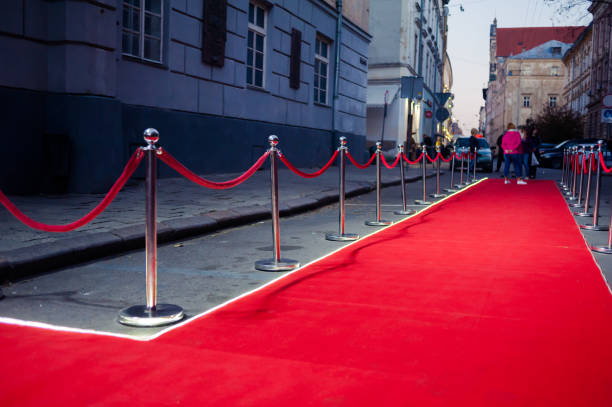 istock Long red carpet between rope barriers on entrance. 1054151376