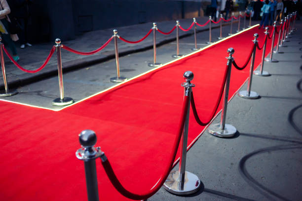 istock Long red carpet between rope barriers on entrance. 1054151686