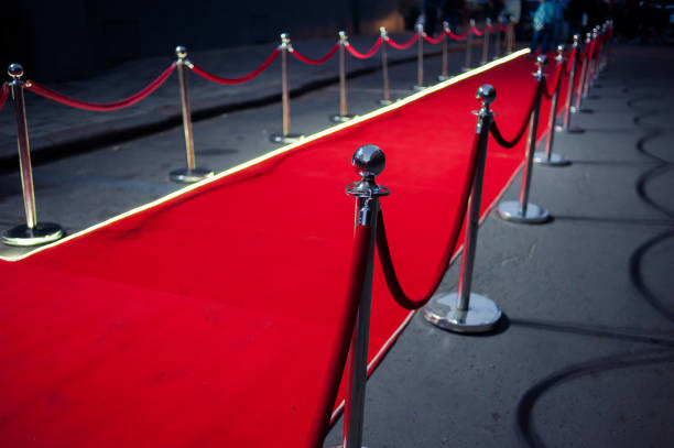 istock Long red carpet between rope barriers on entrance. 1054151730