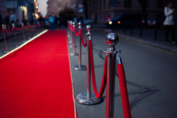 istock Long red carpet between rope barriers on entrance. 1054151768
