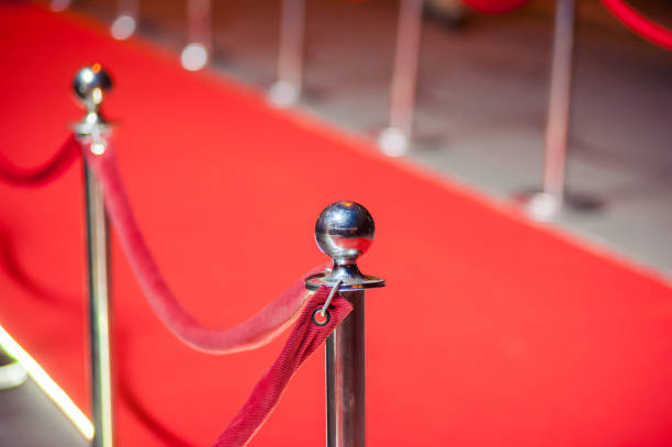 istock Long red carpet between rope barriers on entrance. 1054152012