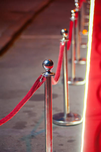 istock Long red carpet between rope barriers on entrance. 1054152098