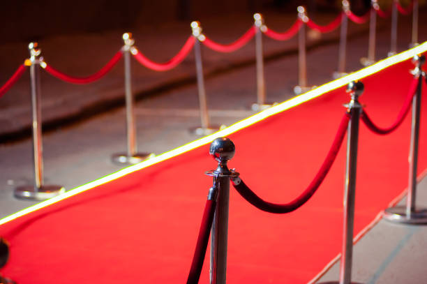 istock Long red carpet between rope barriers on entrance. 1054152126