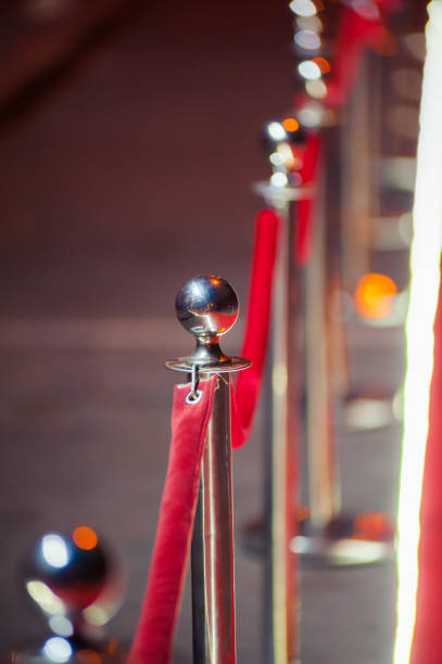 istock Long red carpet between rope barriers on entrance. 1054152142