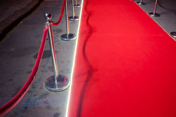 istock Long red carpet between rope barriers on entrance. 1054152188