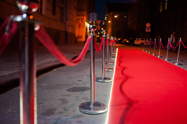 istock Long red carpet between rope barriers on entrance. 1054152324