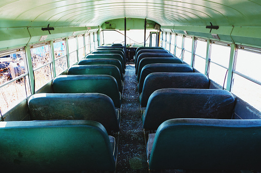 Wide view of the interior of an abandoned school bus.