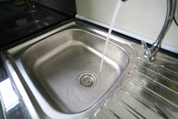 istock stainless dish washing sink and water flow 1054176490