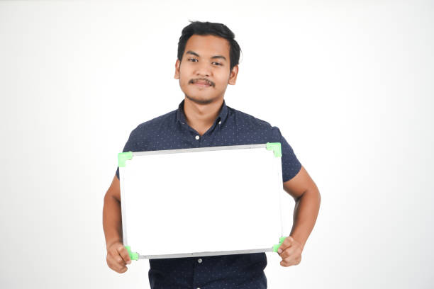 istock Isolated Young Asian Man With Whiteboard 1054186900