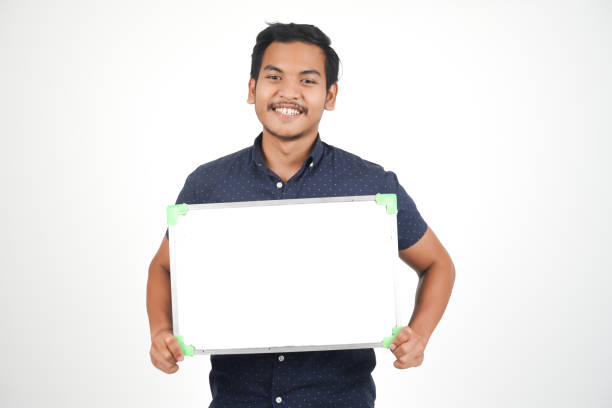 istock Isolated Young Asian Man With Whiteboard 1054187828