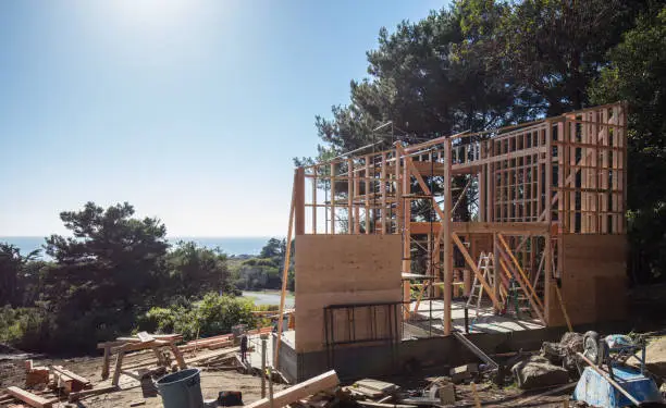 House construction framing in California by pacific ocean on sunny day