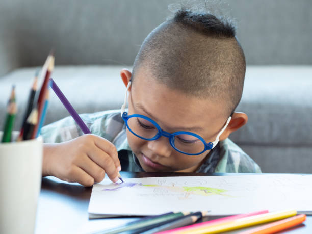 istock Boy intend drawing a picture fun, enjoy drawing or write in book at home. 1054195146