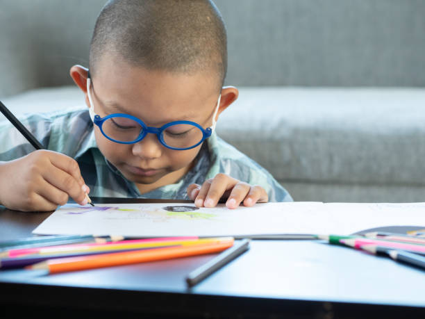 istock Boy intend drawing a picture fun, enjoy drawing or write in book at home. 1054195184