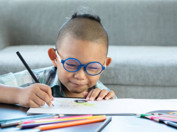 istock Boy intend drawing a picture fun, enjoy drawing or write in book at home. 1054195190