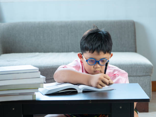 istock Cute asian boy write homework at home. education concept 1054195238