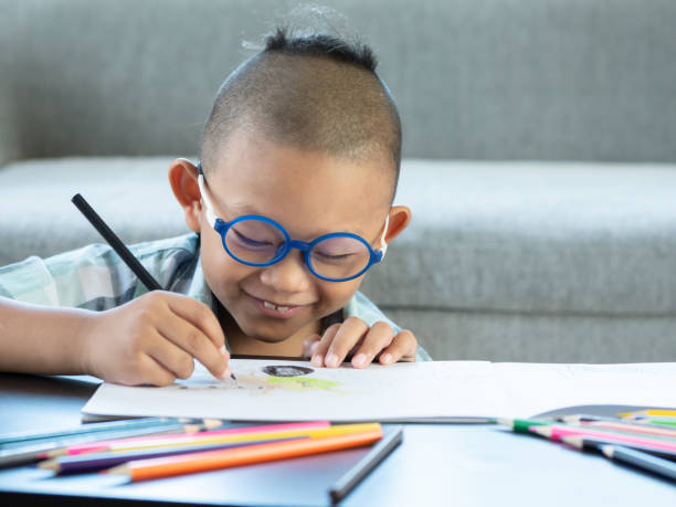 istock Boy intend drawing a picture fun, enjoy drawing or write in book at home. 1054195246