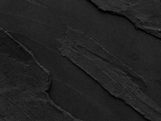 Dark grey black slate with rough background.