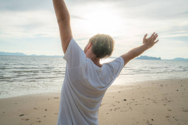 istock Sportive young man stretching on beach after morning jogging 1054222878
