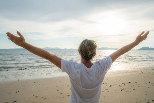 istock Sportive young man stretching on beach after morning jogging 1054222992
