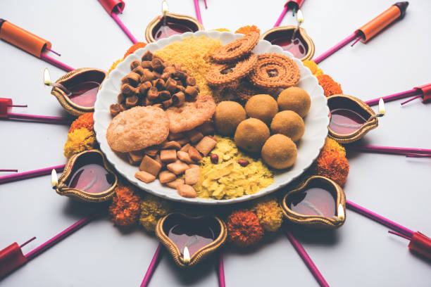 istock Rangoli or design made using Diya/oil lamp with Indian snacks/sweet and firecrackers or patakhe for Diwali festival 1054224950