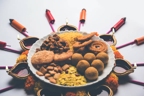 istock Rangoli or design made using Diya/oil lamp with Indian snacks/sweet and firecrackers or patakhe for Diwali festival 1054225084