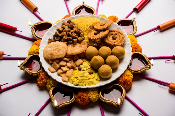 istock Rangoli or design made using Diya/oil lamp with Indian snacks/sweet and firecrackers or patakhe for Diwali festival 1054225116
