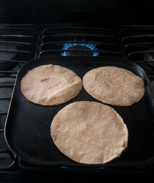 istock Warming up tortillas on top of a COMAL 1054236144