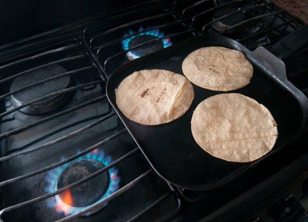 Warming up tortillas on top of a COMAL