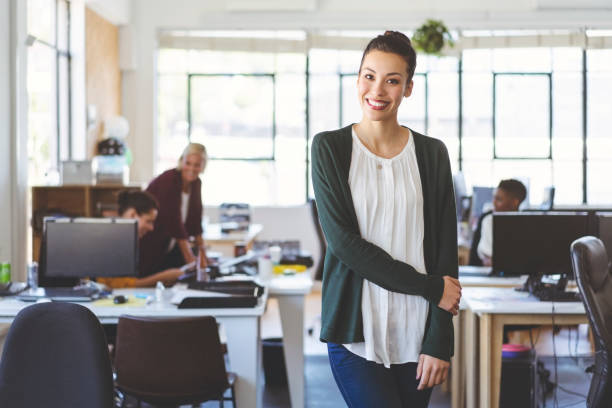 istock Smiling young businesswoman standing in office 1054241302