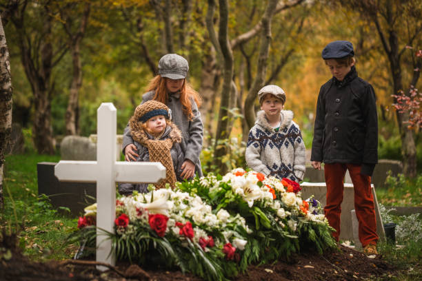 dzieci odwiedzające grób zmarłego bliskiego. - cemetery child mourner death zdjęcia i obrazy z banku zdjęć