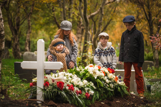 children visiting grave of deceased loved one. - cemetery child mourner death imagens e fotografias de stock